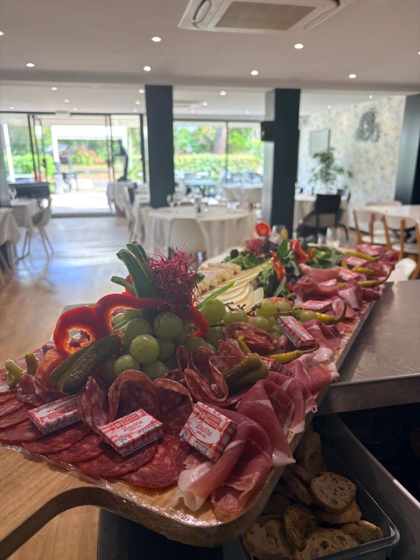Planche de charcuteries et crudités dressée dans la salle pour un apéritif dînatoire
